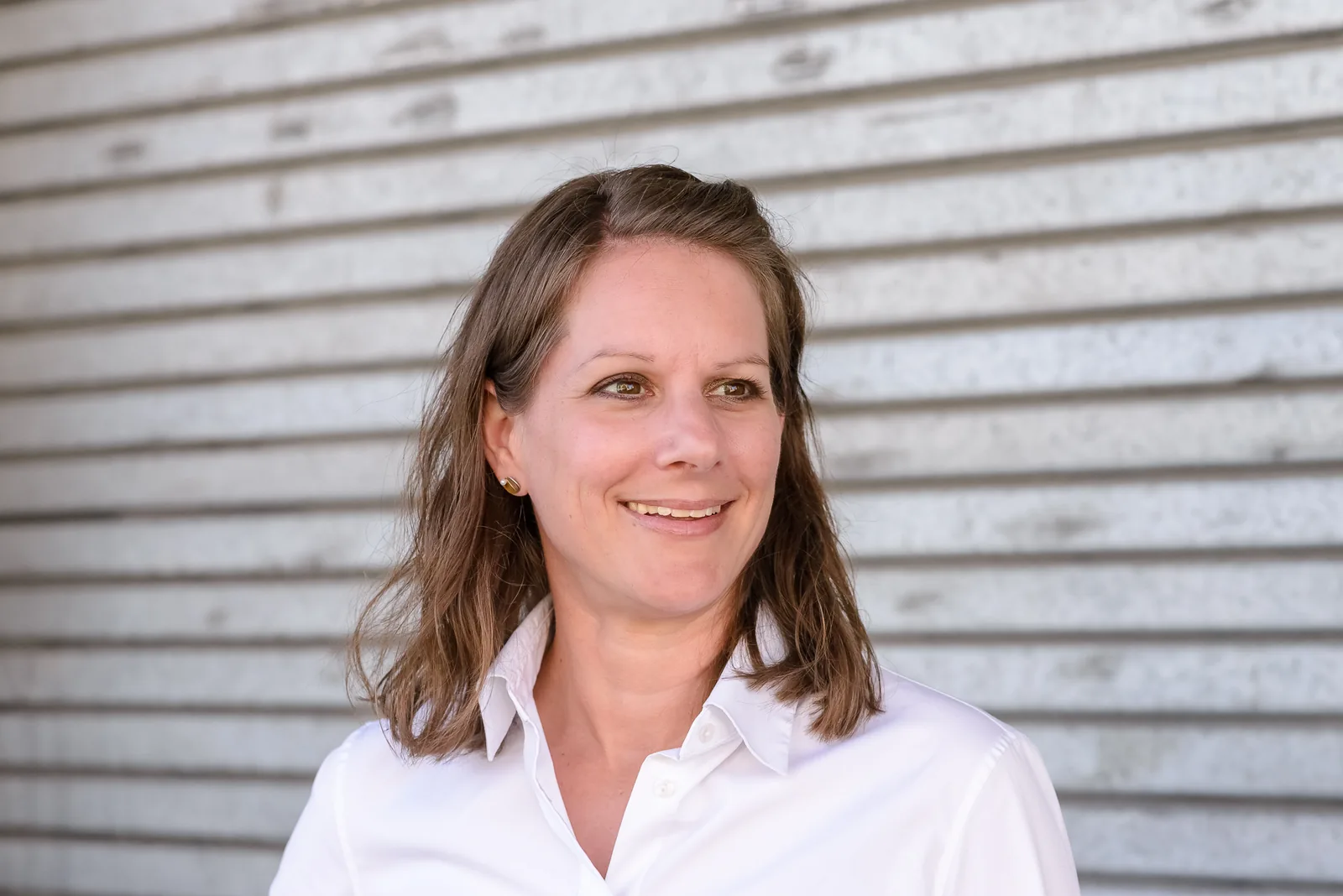 Leila Steiner vor einer Wellblechwand.