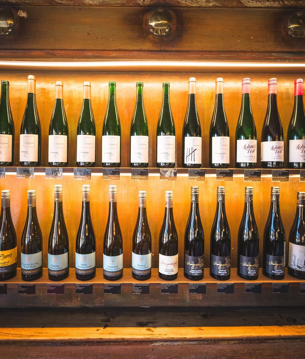 Weinwand im Wilädeli: zwei Reihen Flaschen in einem beleuchteten Holzregal